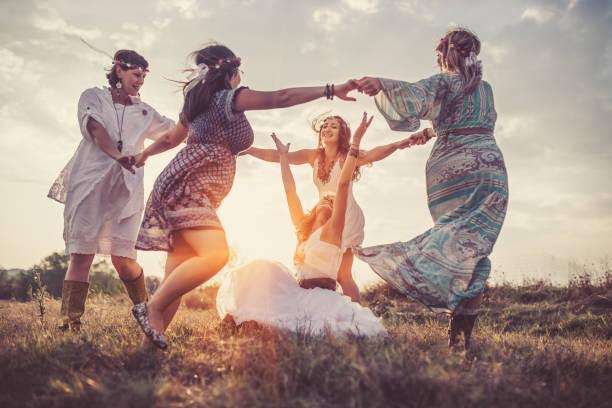 Group of happy female friends running on meadow.